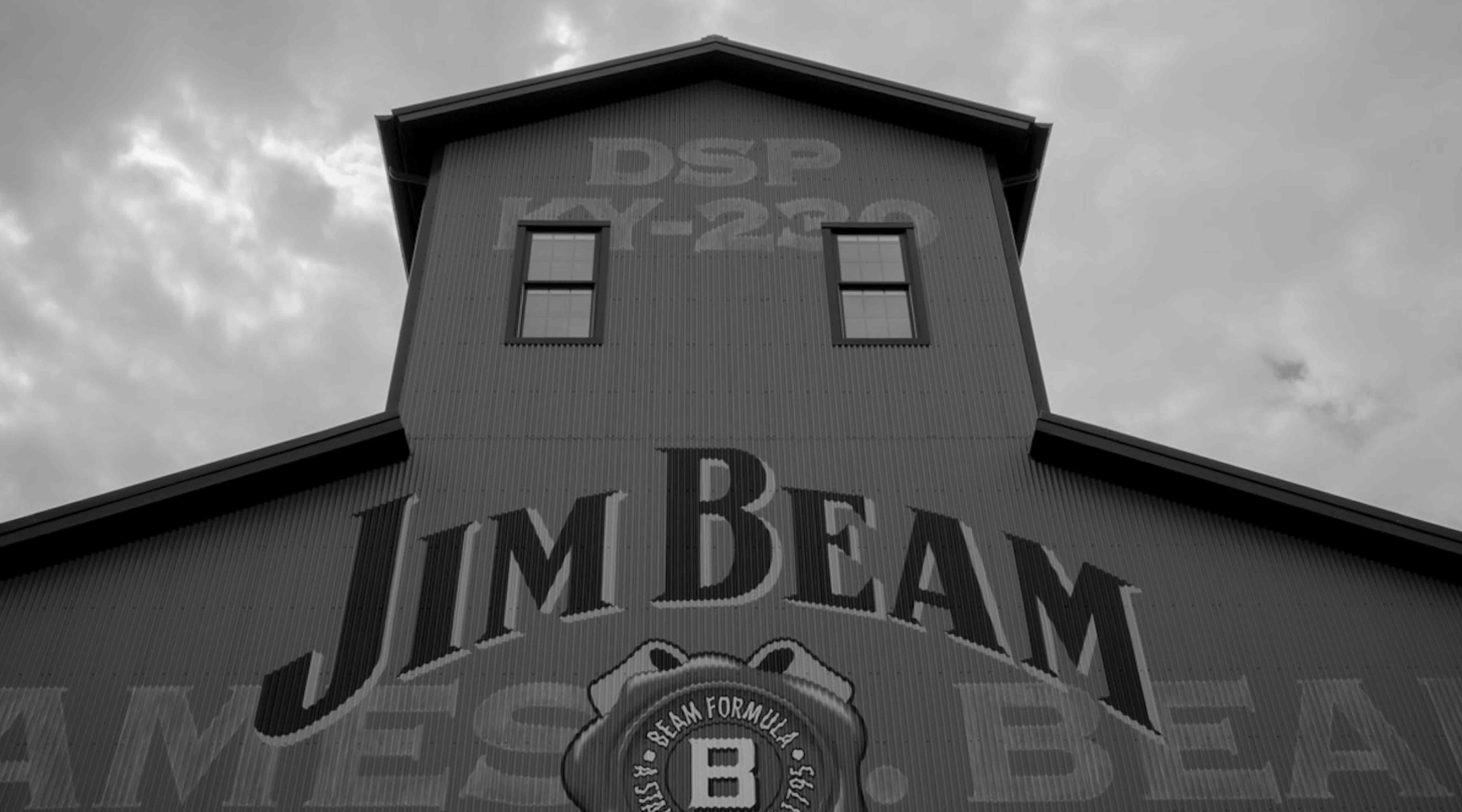 Black and white corrugated distillery building with large 'JIM BEAM' lettering—Make History movement modernizing a bourbon icon for a new generation