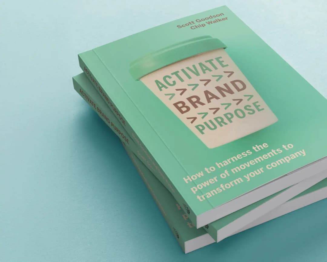 Stack of three light green books on a blue surface, with the top book showing "ACTIVATE BRAND PURPOSE" in a coffee cup design, authored by Scott Goodson and Chip Walker, with subtitle about harnessing movements to transform companies.