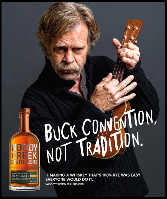Poster of actor William H. Macy playing the ukulele while advertising Woody Creek Distillers. 